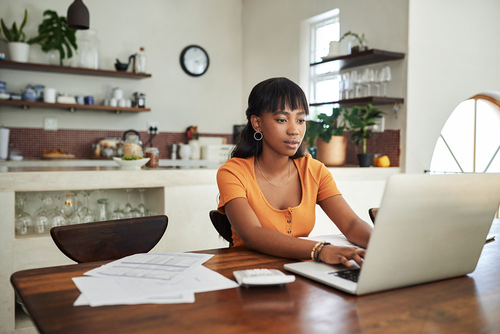 Woman at home table looking at laptop